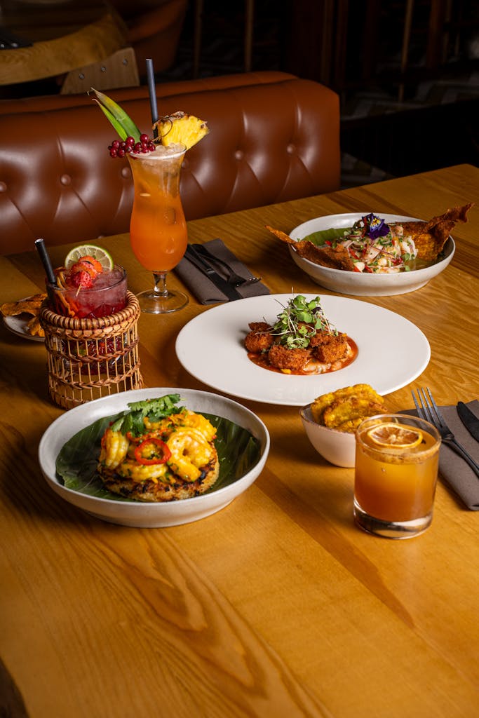 A delectable spread of gourmet dishes paired with vibrant cocktails at a stylish restaurant.